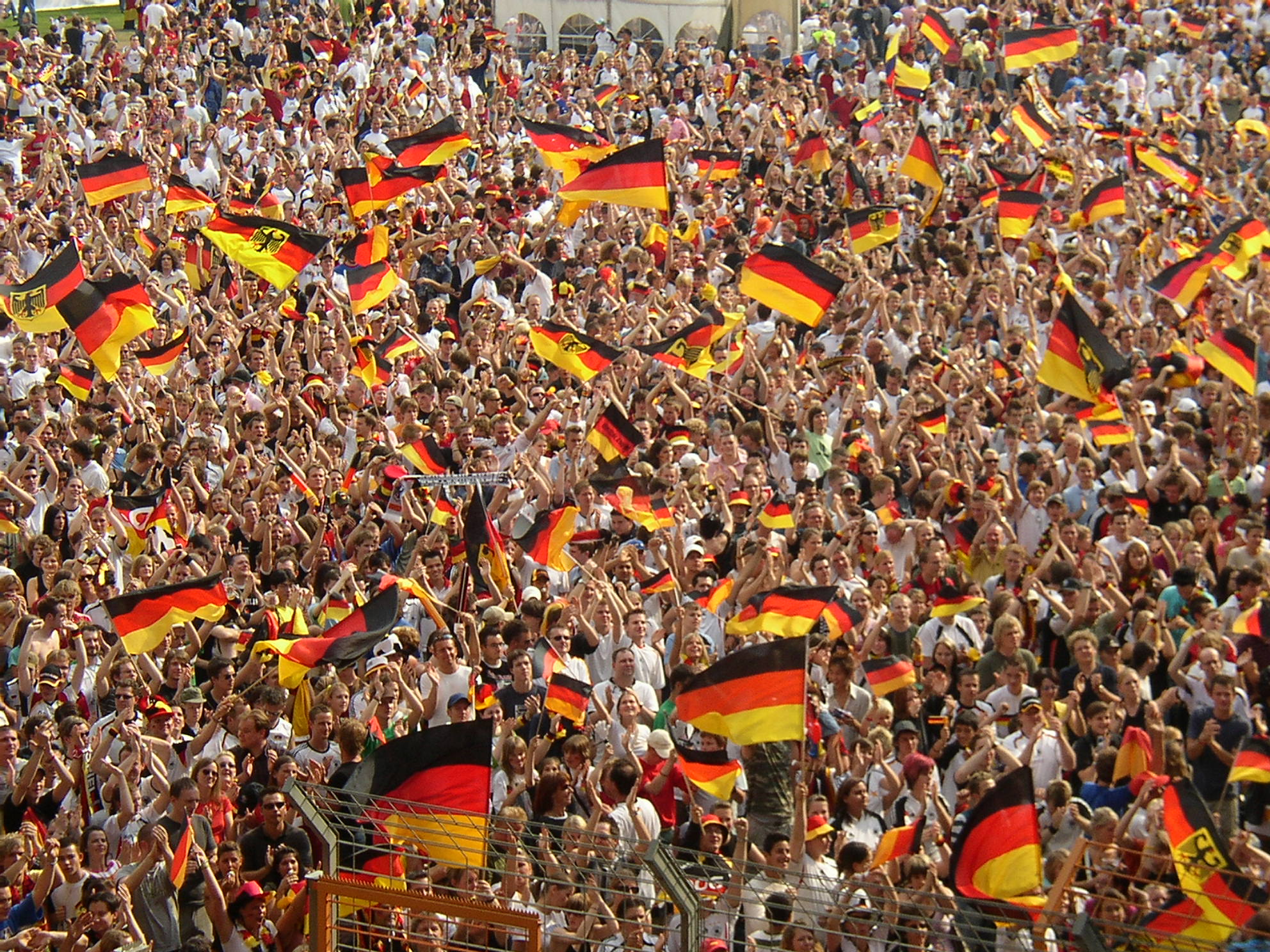 National team supporters waving flags in a stadium crowd